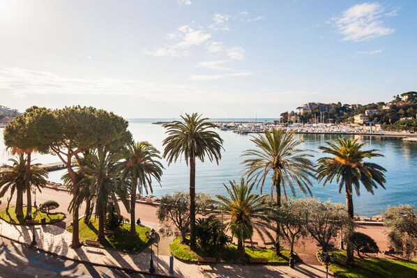 A coastal marina with boats, palm trees, and a clear sky. - Hotel Vesuvio (Rapallo)
