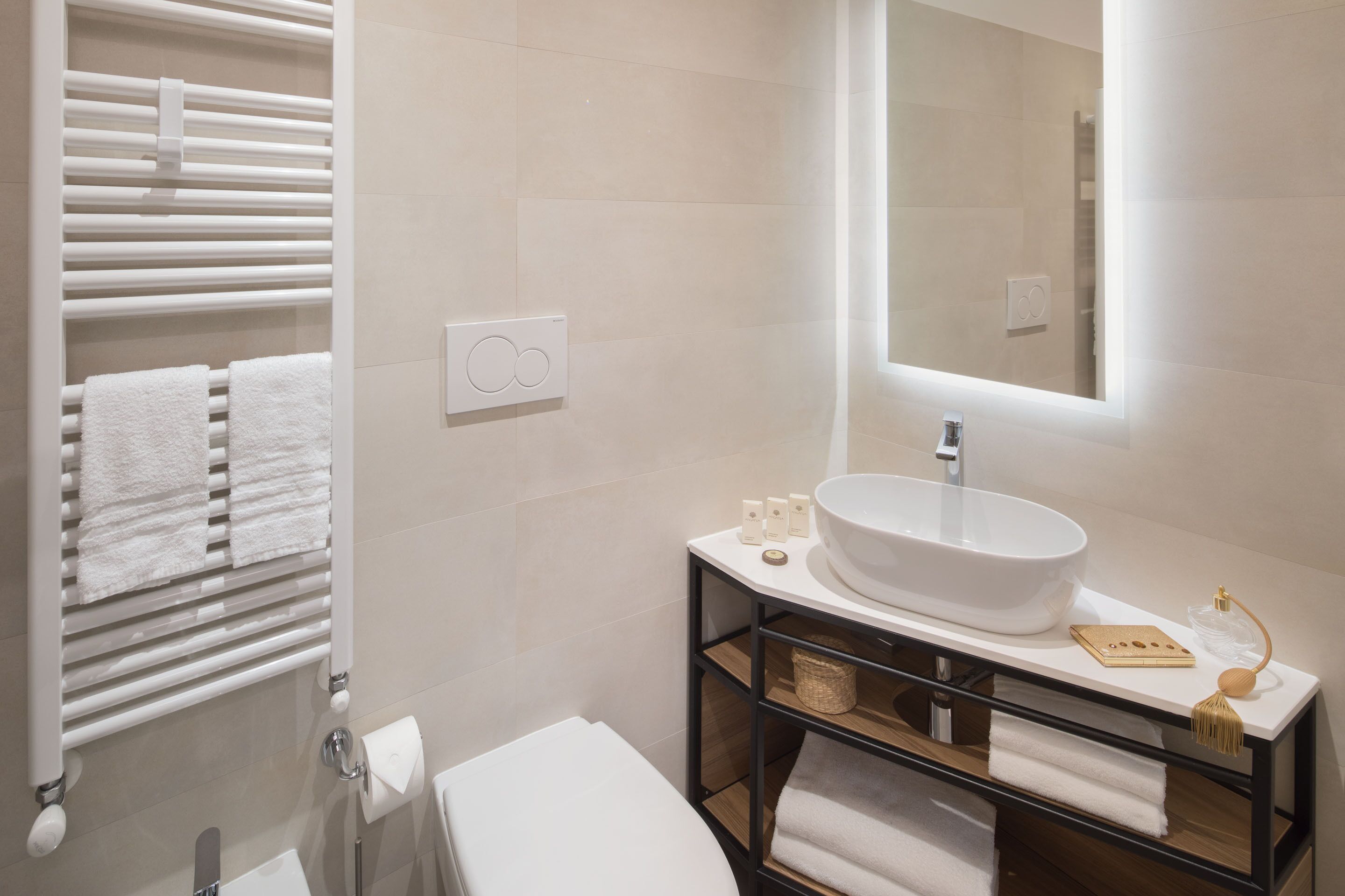 A modern bathroom with a white sink, a mirror, and a towel rack.