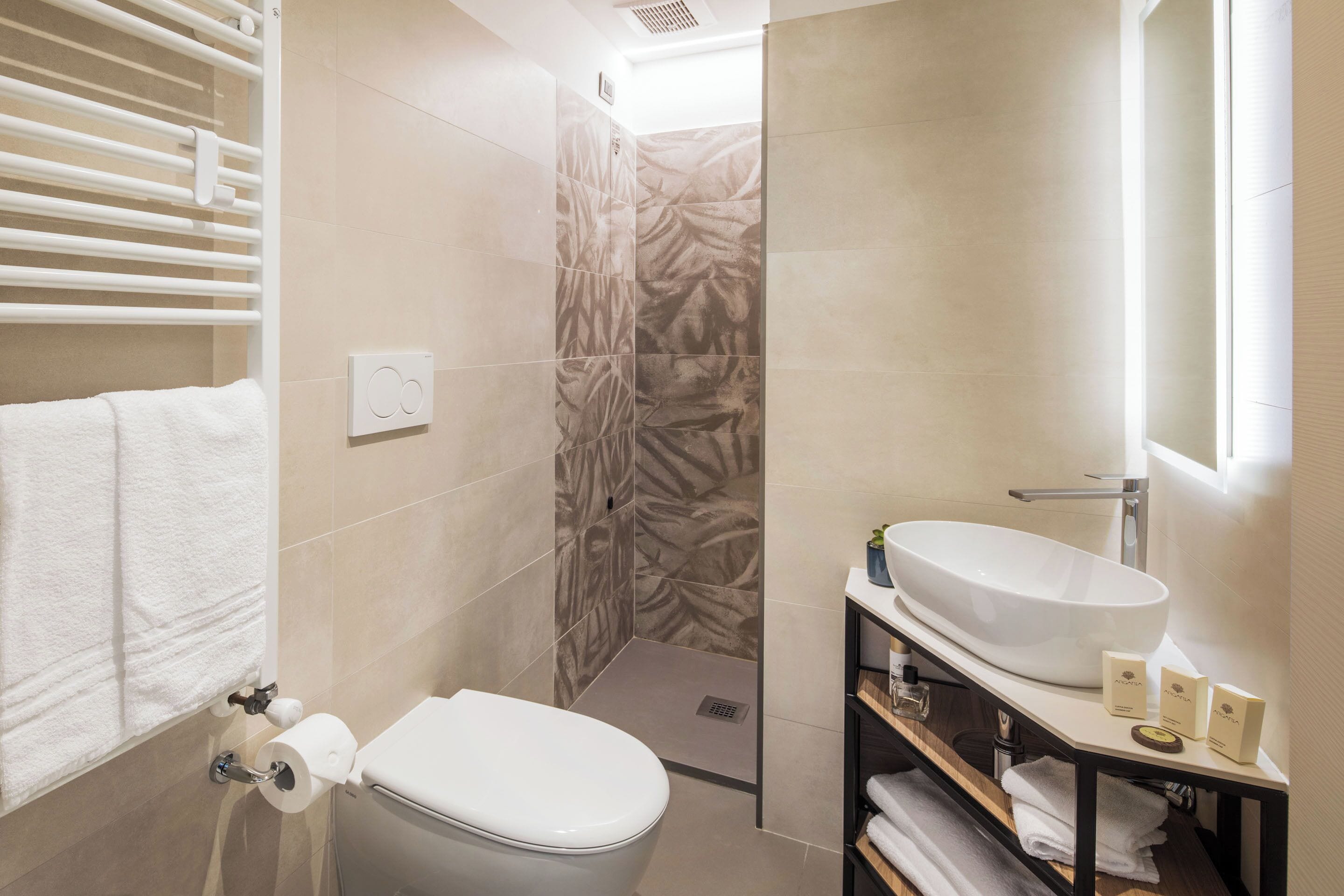 Une salle de bain moderne équipée de toilettes, d’une douche et d’un lavabo.