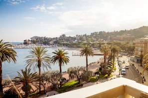 A coastal cityscape with a marina, palm trees, and buildings along the waterfront. - Hotel Vesuvio (Rapallo)