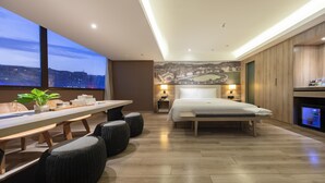 Une chambre d’hôtel moderne, dotée d’un grand lit, d’une table à manger et offrant une vue sur le paysage urbain.