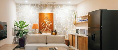 A modern kitchen with a stone wall, a black refrigerator, wooden cabinets, and a built-in oven.