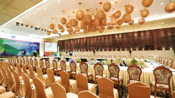 Ein Konferenzraum mit Reihen von Tischen und Stühlen, einer Bühne und einem Banner zur Konferenz der Finanzminister des APEC.