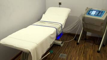 Guest rooms feature a patient bed with a medical device for monitoring heart activity.