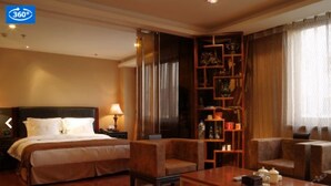 A hotel room with a bed, two armchairs, a coffee table, a nightstand, and a bookshelf. - Dong Jiao Min Xiang (Beijing)