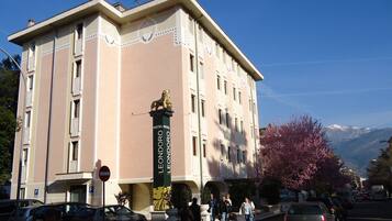 A hotel with a prominent column featuring a lion statue and the name 'LEONORO LEONORO'.