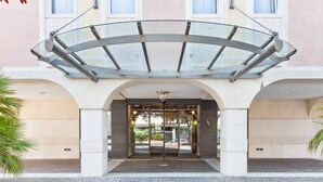 A hotel entrance with a glass canopy, a central door, and a tiled ground. - Leon d'Oro (Rovereto)