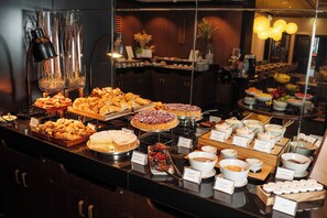 A buffet with various food items and a coffee station.