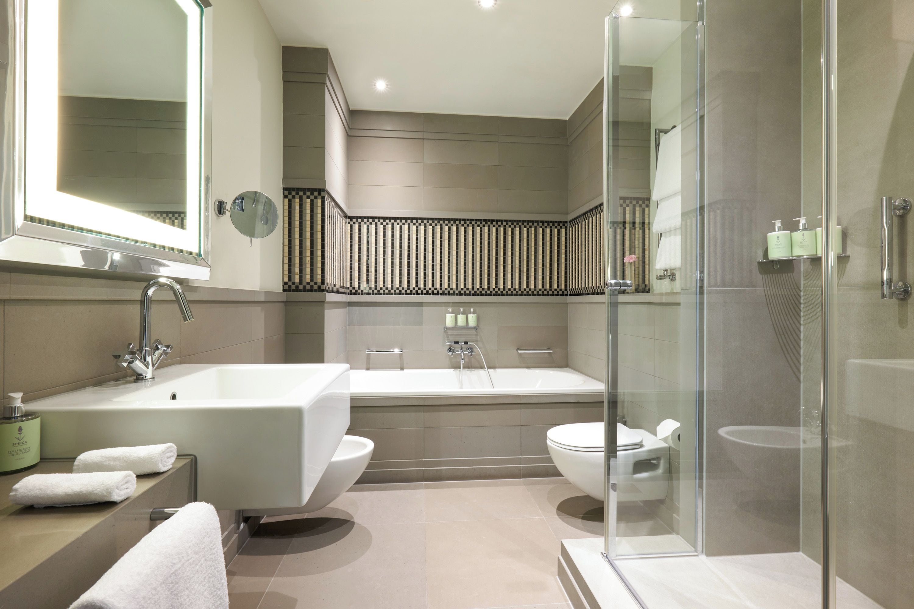 A modern bathroom with a freestanding bathtub, a glass-enclosed shower, and a large mirror.