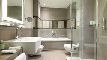 A modern bathroom with a freestanding bathtub, a glass-enclosed shower, and a large mirror.
