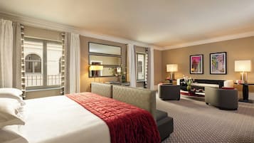 Une chambre d’hôtel avec un grand lit, un canapé, un bureau et une vue sur l’extérieur.