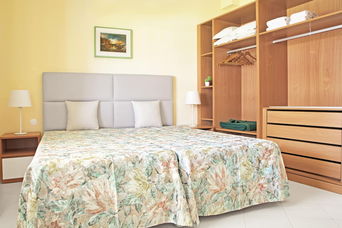 1 habitación, escritorio y tabla de planchar con plancha