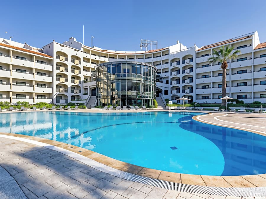 Una piscina al aire libre, sillones reclinables de piscina