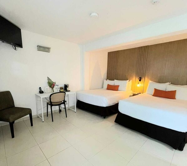 Une chambre d’hôtel avec deux lits, un bureau, une chaise et un téléviseur.