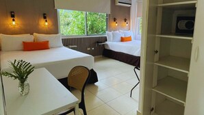 A modern hotel room with a bed, a desk, and a wardrobe.