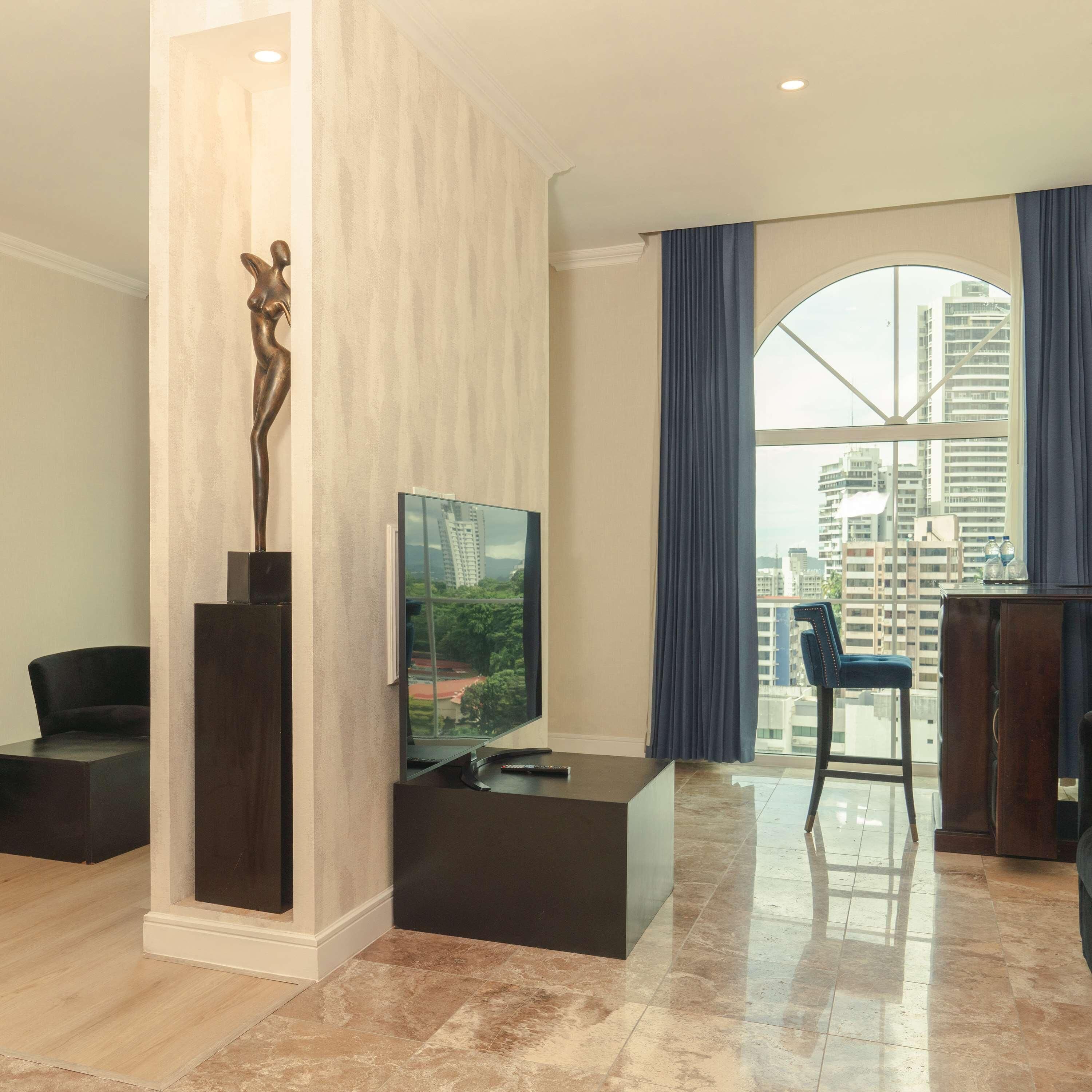 أغطية فراش متميزة وخزنة داخل الغرفة ومكتب وستائر تعتيم