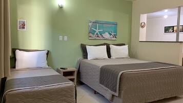 A hotel room with two beds, a nightstand, a painting, and a mirror.