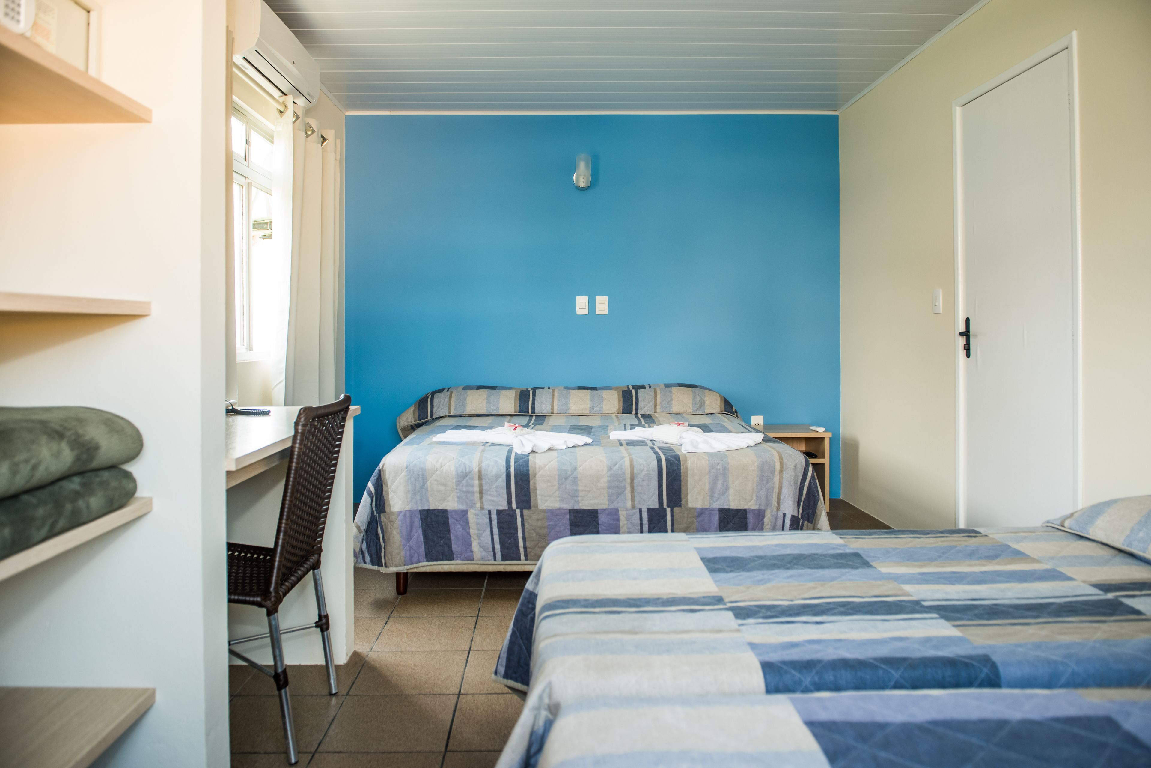 Een slaapkamer met twee bedden, een bureau en een stoel.