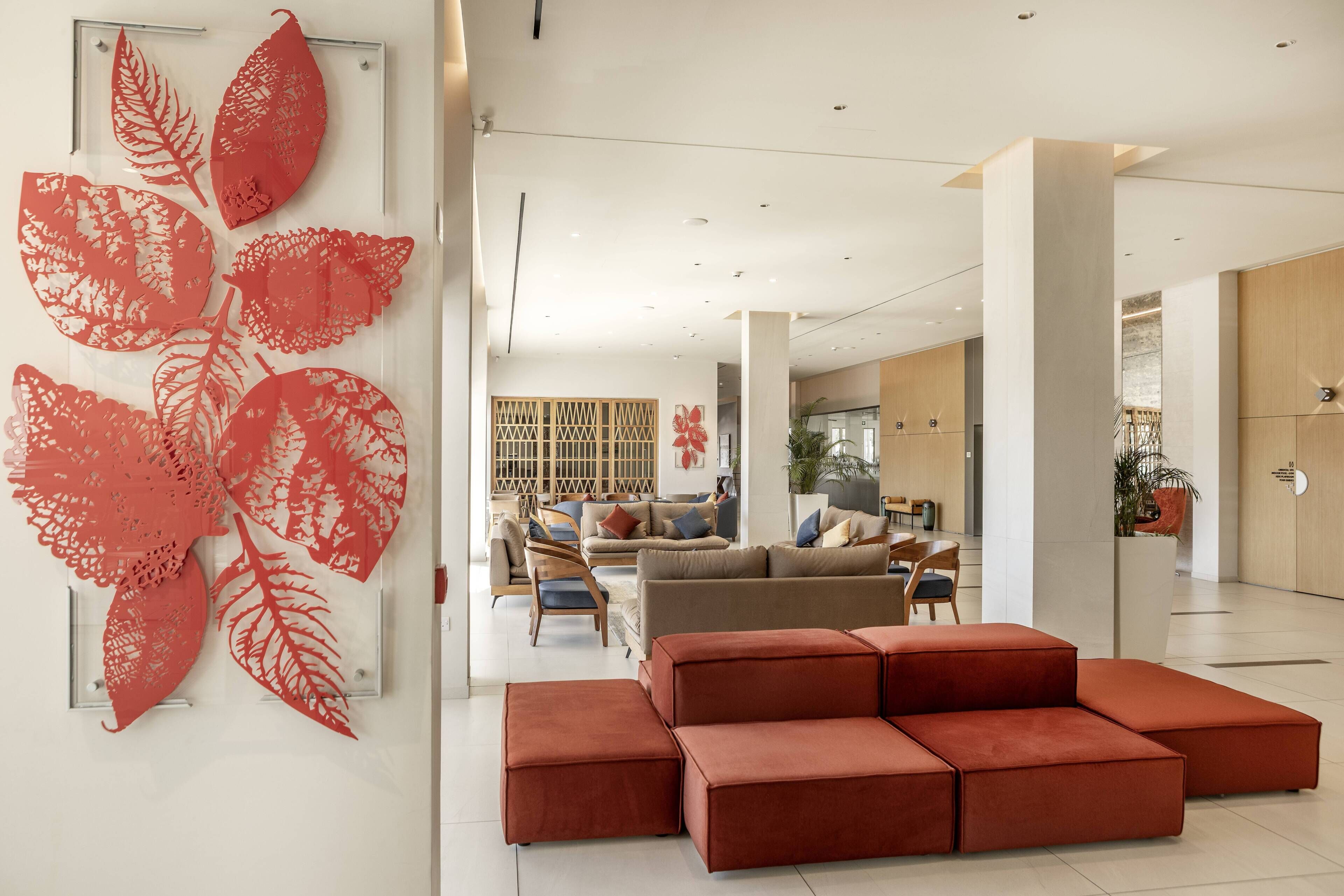 A modern interior with a seating area, a large wall art piece, and a staircase.