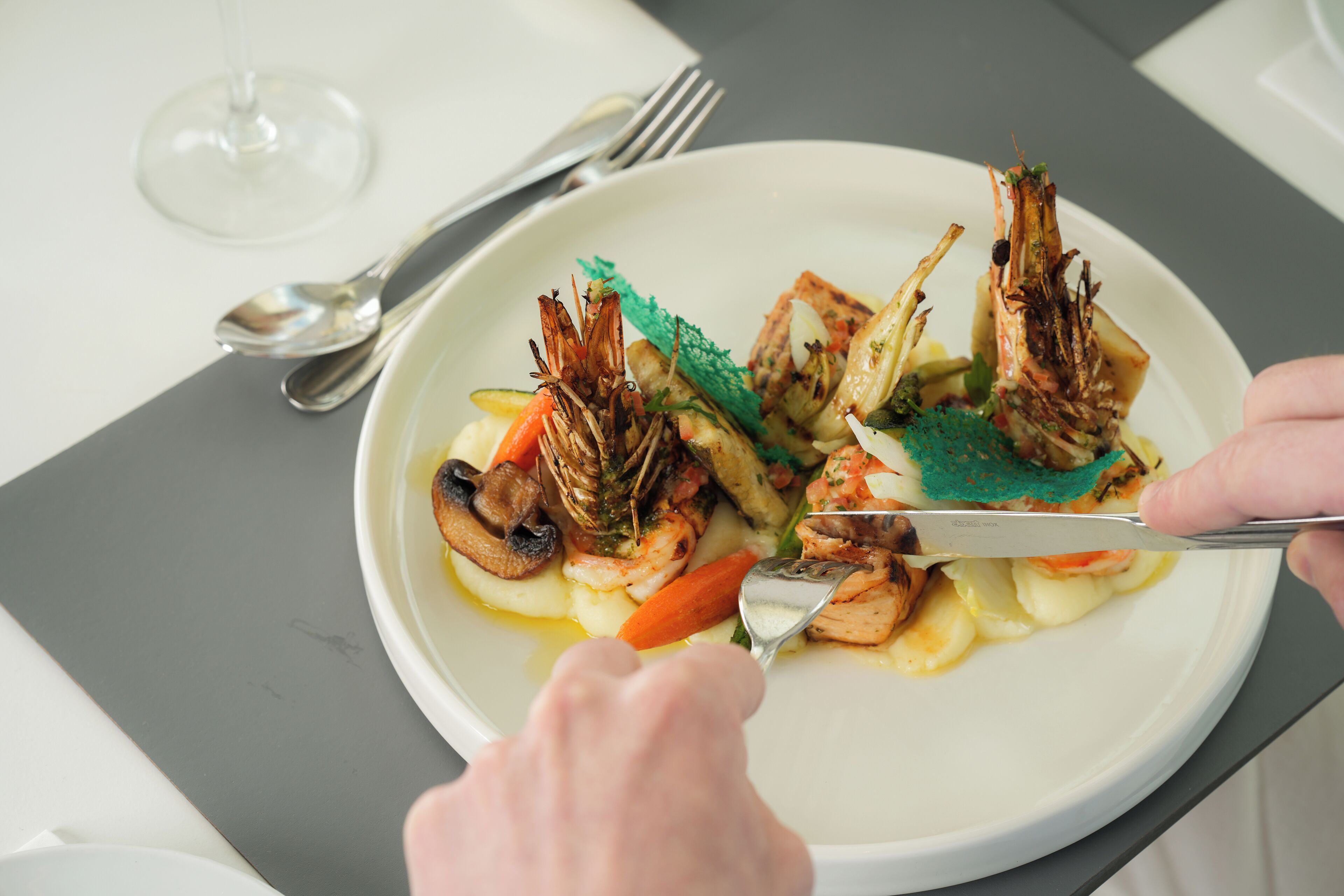 A plate of food with shrimp, vegetables, and a garnish.