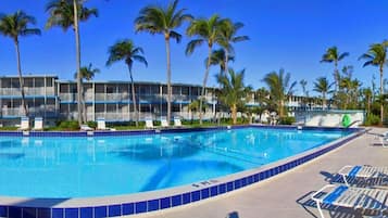 Alberca al aire libre, sombrillas en la alberca y camastros