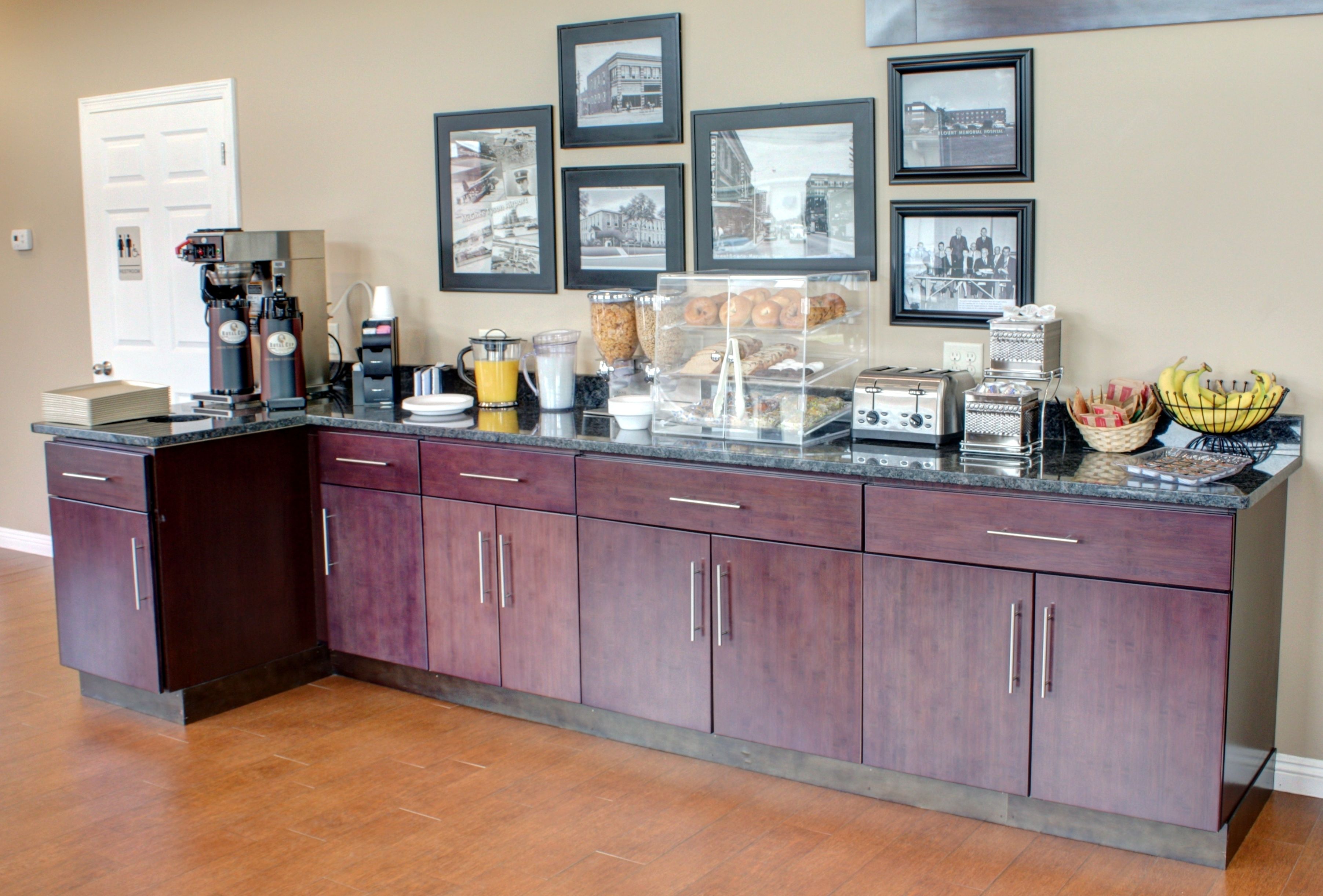 A kitchen with a marble countertop, a coffee machine, a toaster, and a fruit bowl.