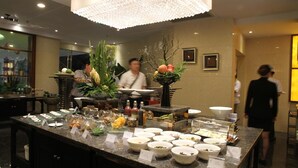 Een buffetopstelling met diverse gerechten en een decoratief middelpunt.