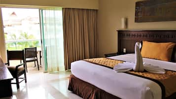 Habitación de hotel con cama, escritorio, silla y vistas al exterior.