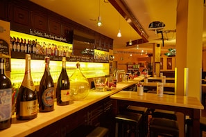 Un espace bar avec des bouteilles de vin et un projecteur fixé au plafond.