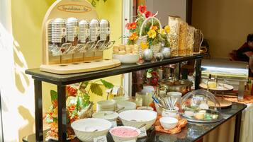 Uma mesa de buffet com diversos alimentos e uma estação de café.