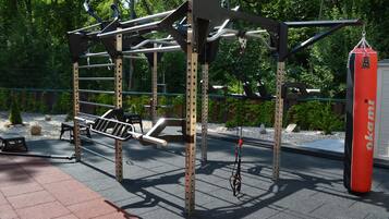 Una estructura metálica de gimnasio con barras de dominadas y un saco de boxeo.