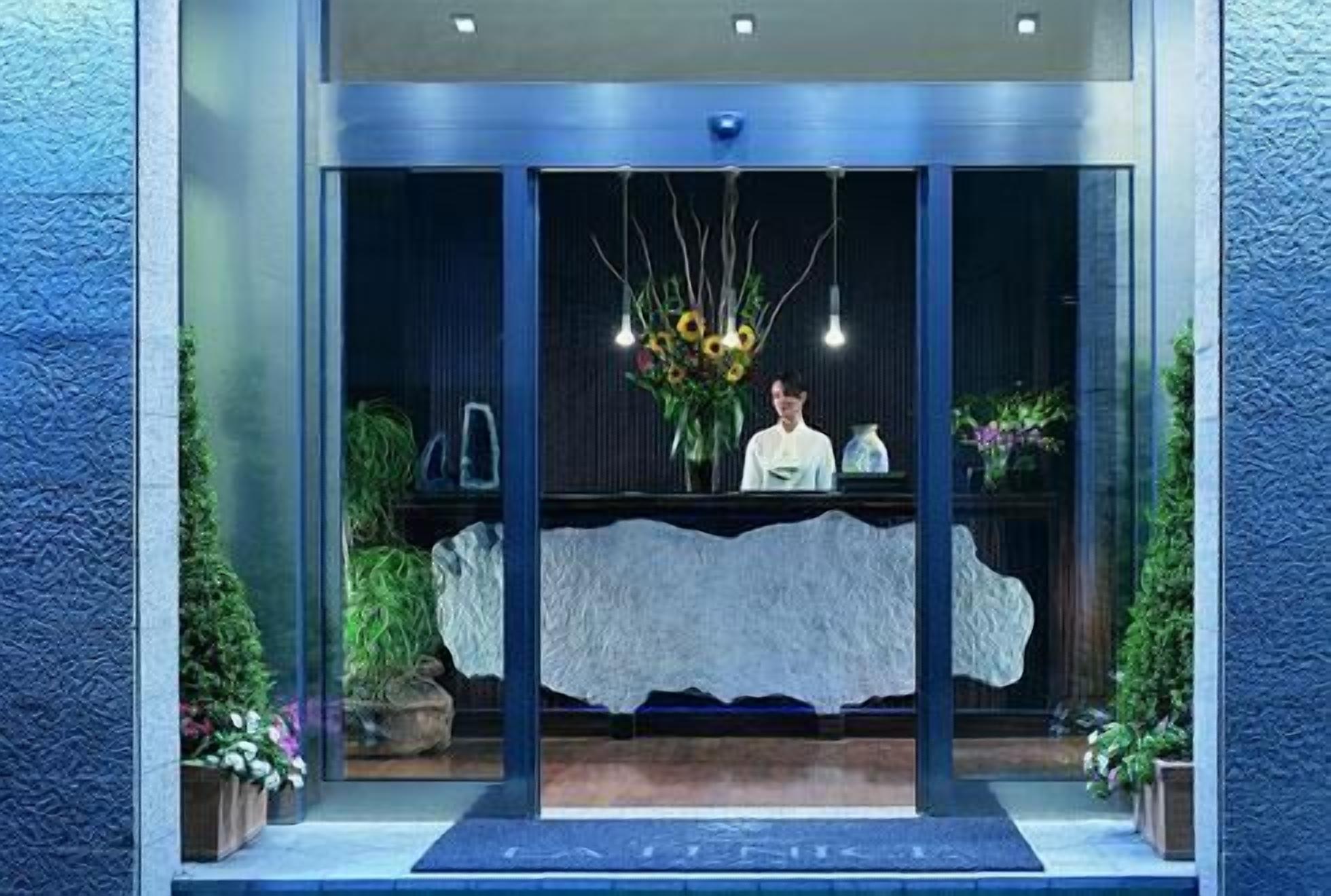 A reception area with a receptionist, a reception desk, and a large window.
