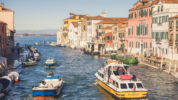 A canal with boats, buildings, and a clear sky. - Locanda Ca' Lucrezia (Venice)