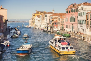 A canal with boats, buildings, and a clear sky.