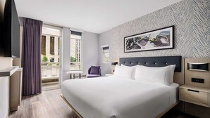 A modern hotel room with a large bed, a flat-screen TV, a desk, and a window with a view of the outdoors. - Manhattan Centre Hotel (New York)