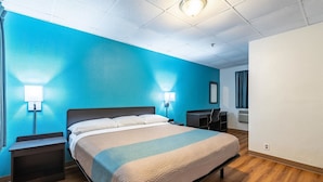 Une chambre d’hôtel avec un lit, des tables de chevet, un bureau et une chaise.