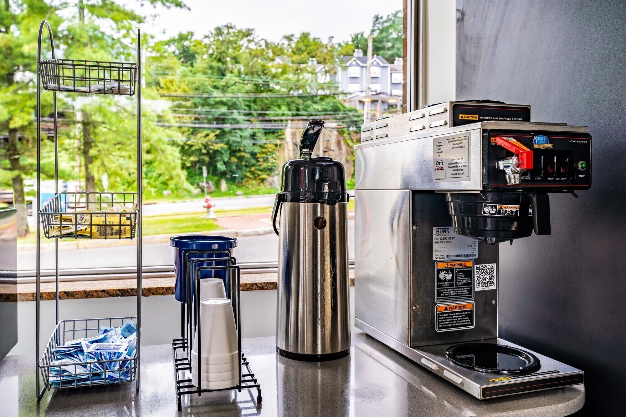 A coffee machine with a digital display and a coffee pot on a countertop.