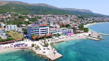 Pantai pribadi, pasir putih, kursi berjemur, dan payung pantai