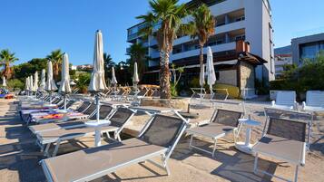 Playa privada, playa de arena blanca, camastros y sombrillas