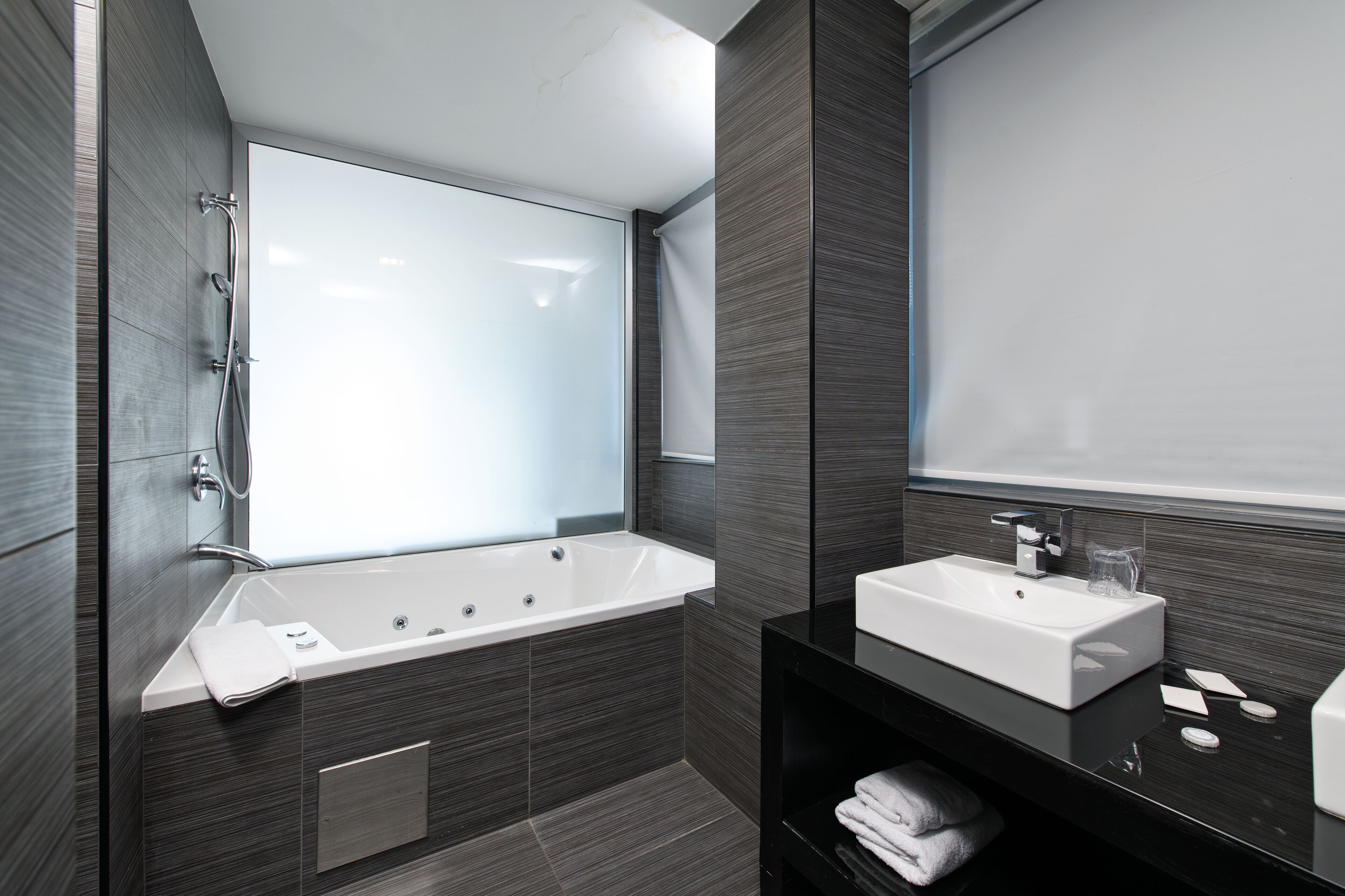 Une salle de bain moderne avec une grande baignoire, un lavabo et un miroir.