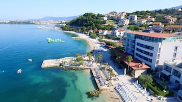 Pantai pribadi, pasir putih, kursi berjemur, dan payung pantai