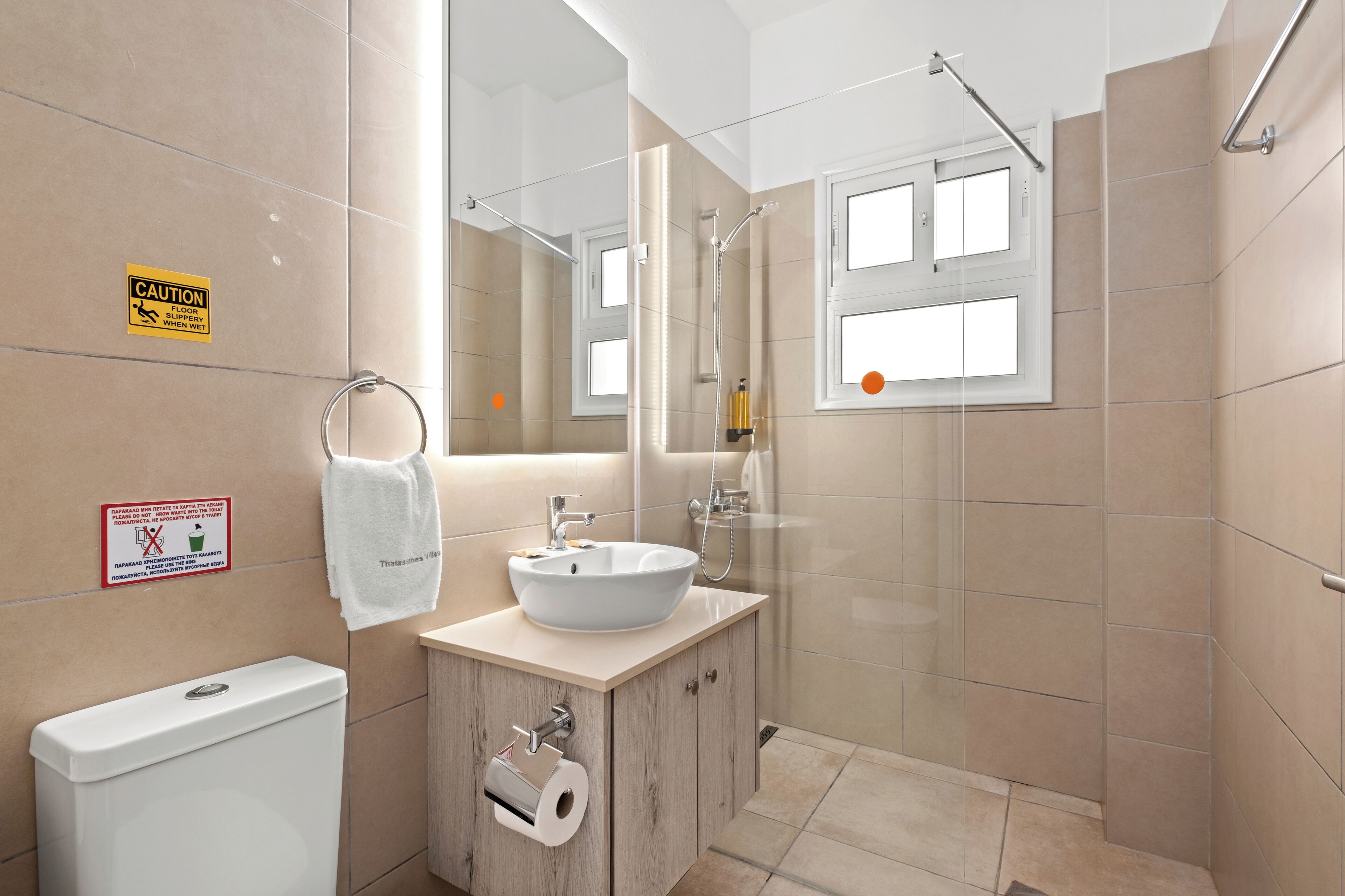 Un baño moderno con lavabo, espejo y ducha.