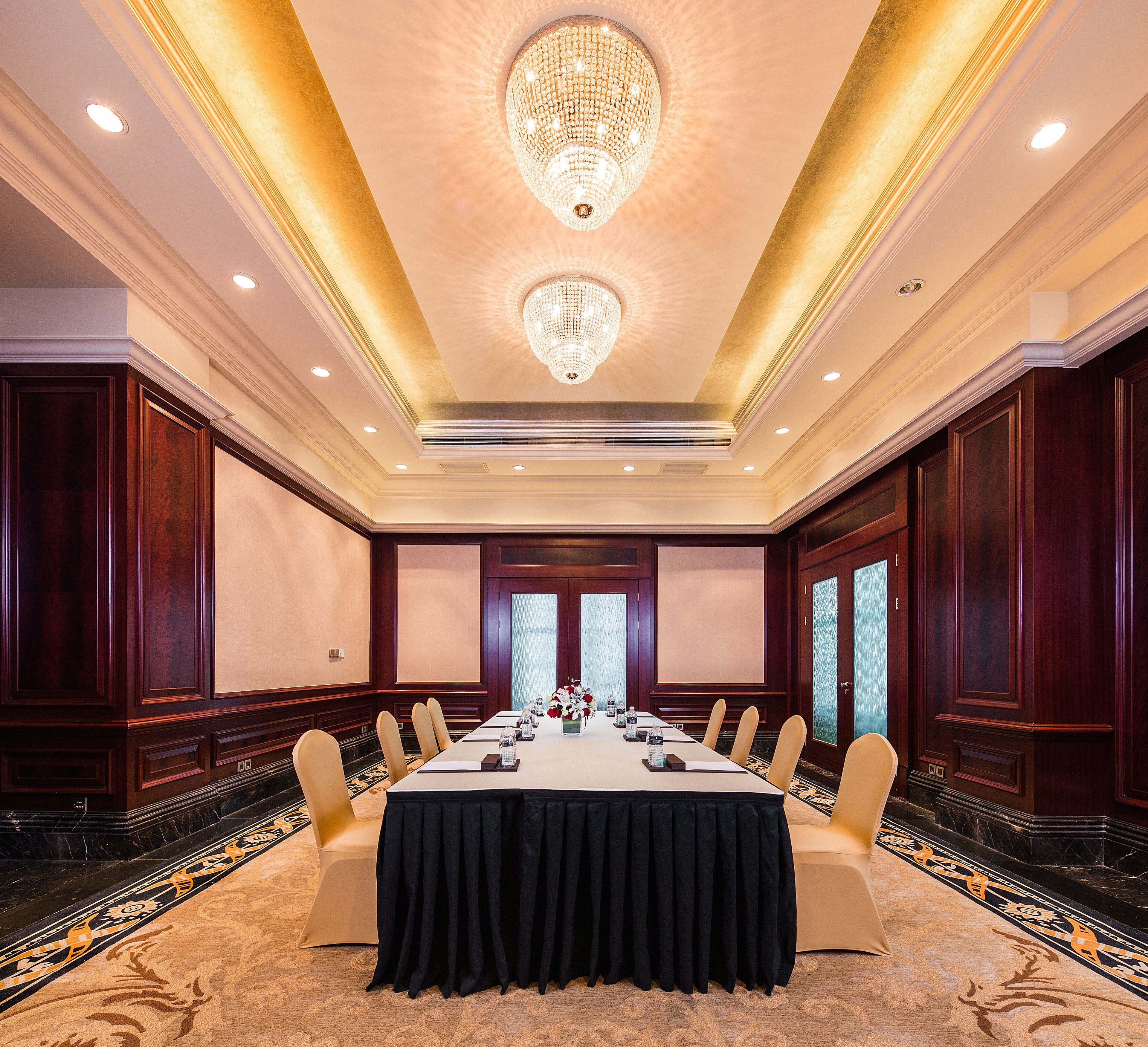 A conference room with a long table, chairs, and a chandelier.
