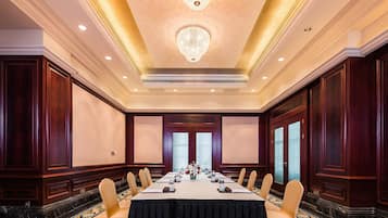 A conference room with a long table, chairs, and a chandelier.