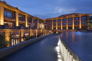 Un hotel con un patio amplio, una fuente y una piscina.