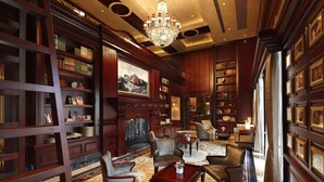A library with bookshelves, a chandelier, and a fireplace. - InterContinental Shanghai Ruijin by IHG (Shanghai)