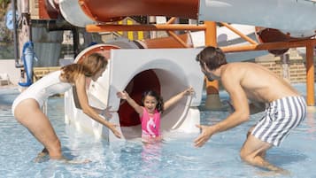 Zona de piscina con tobogán y estructura de juegos.