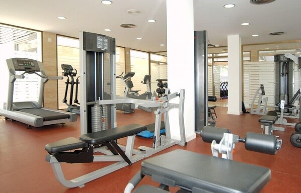 A gym with treadmills, weight machines, and free weights.