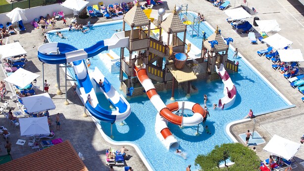A water park with multiple slides and pools, surrounded by sun loungers and umbrellas. -  Hotel Rosamar Benidorm (Benidorm)