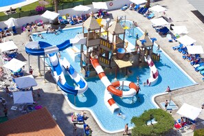 A water park with multiple slides and pools, surrounded by sun loungers and umbrellas. -  Hotel Rosamar Benidorm (Benidorm)